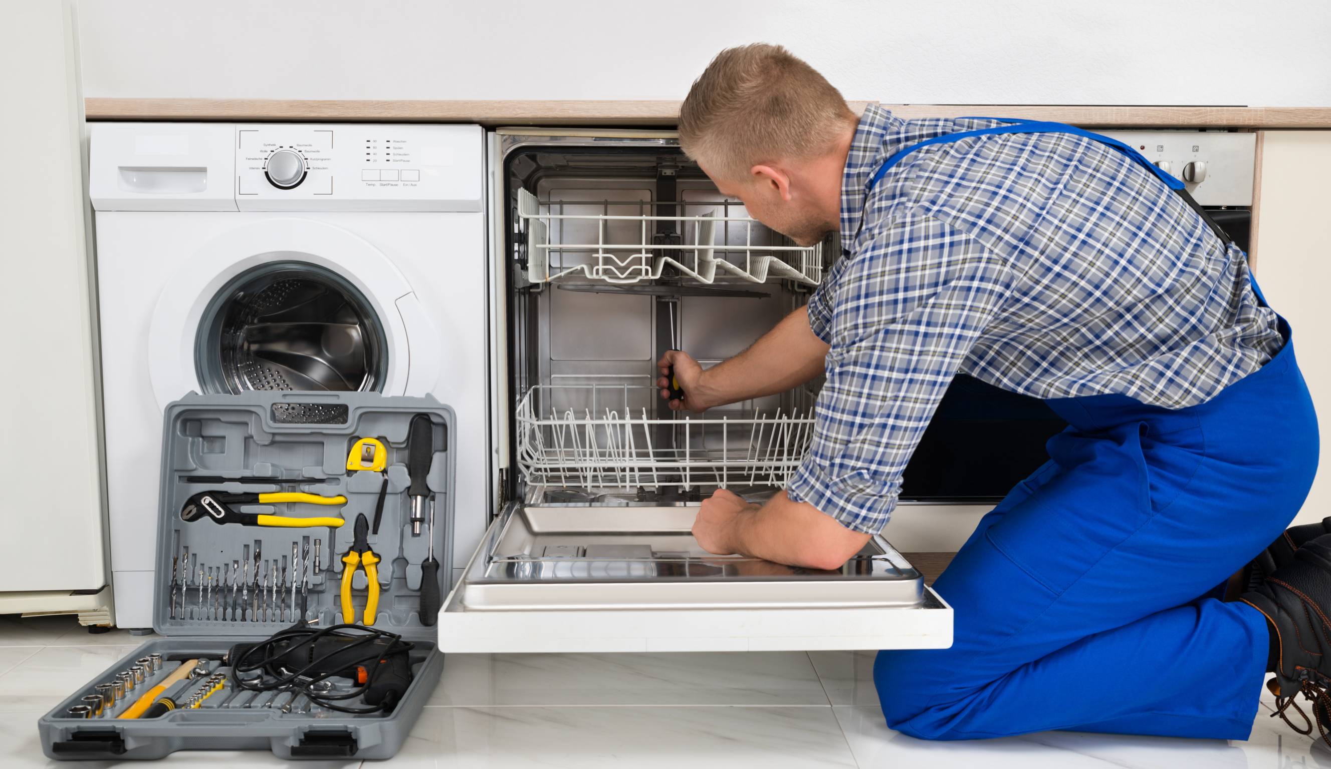 Smile Appliances technician repairing a dishwasher in a Toronto kitchen